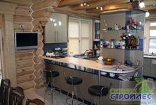 Интерьер кухни-столовой в деревянном доме из оцилиндрованных бревен